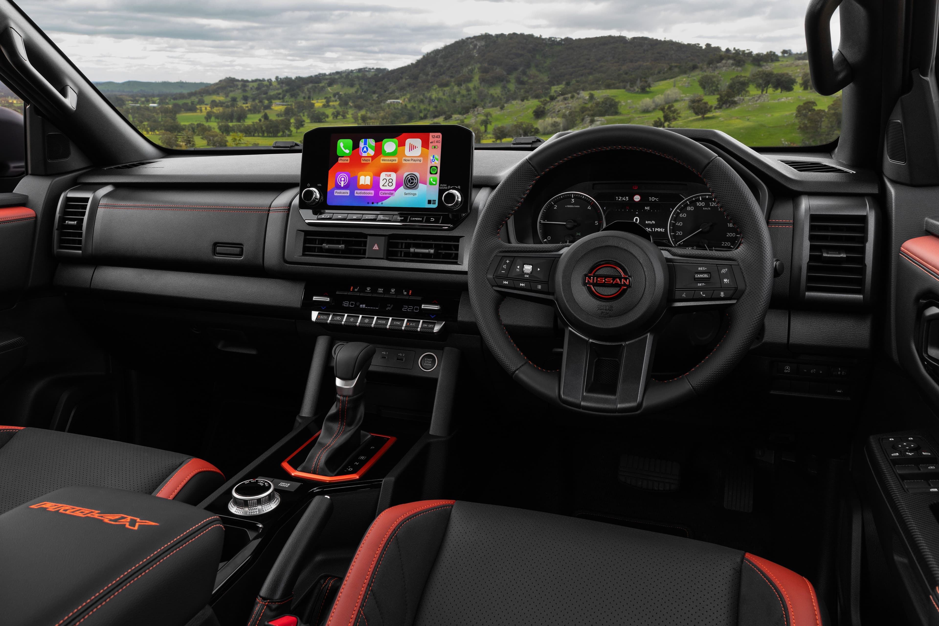 2026 Nissan Navara PRO-4X dual cab ute in Kimberley Orange driving on Australian dirt road